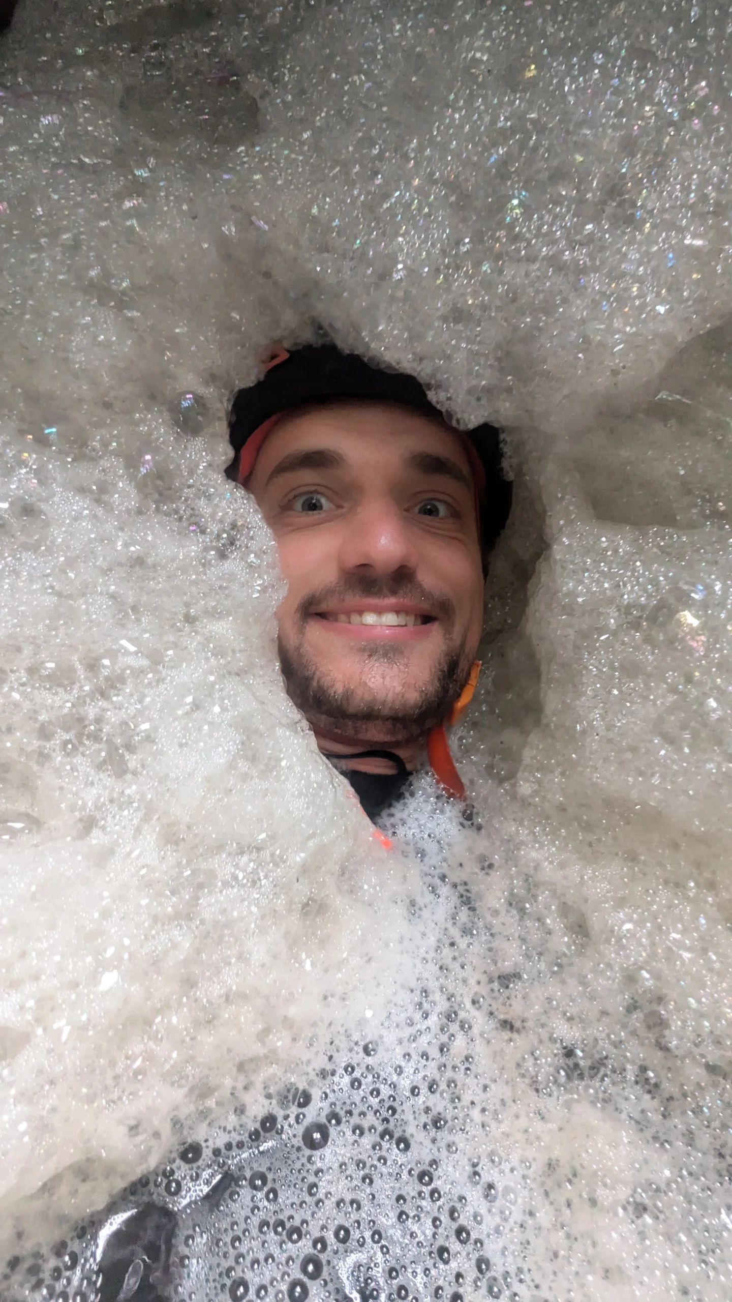 Moniteur de canyoning observant de la mousse naturelle dans une vasque de canyon